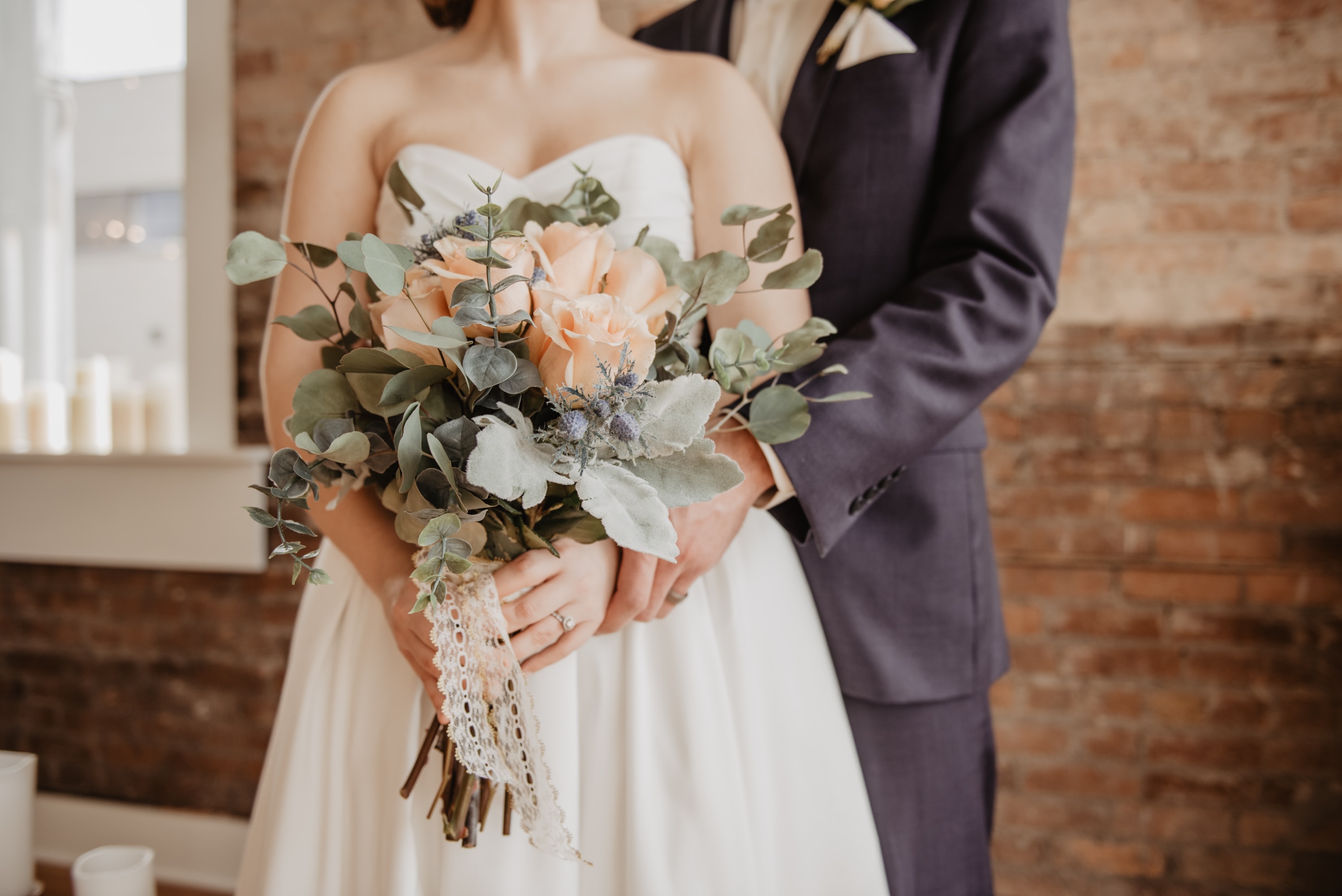 A gride and groom at wedding with a bouquet of flowers